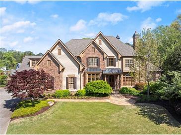 Stunning two-story brick home featuring a manicured lawn, lush landscaping, and a welcoming front entrance at 3562 Langley Oaks Se Ct, Marietta, GA 30067