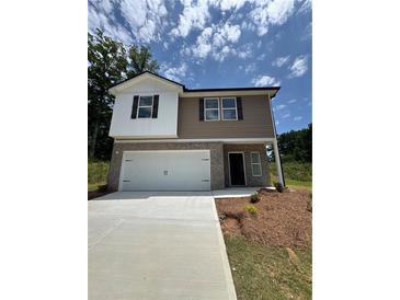 Charming two-story home features a two-car garage, brick facade, and landscaped front yard at 111 Deer Xing, Temple, GA 30179