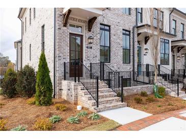 Attractive townhome showcasing a brick facade, black accents, and manicured landscaping at 560 Fisher Dr # 48, Alpharetta, GA 30009
