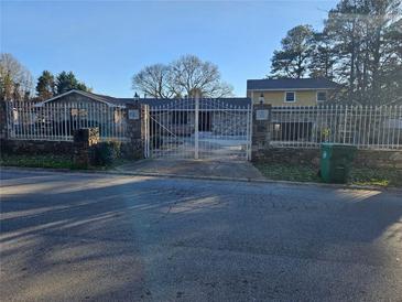 Charming home with a decorative metal fence and stone accents at 6419 Edenfield Dr, Lithonia, GA 30058
