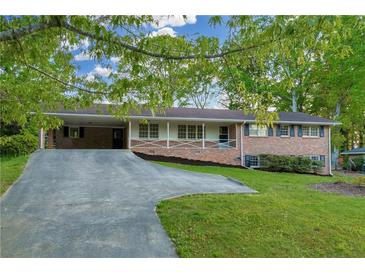 Charming brick home with a covered carport and a welcoming front porch at 2027 Kensington High Sw St, Lilburn, GA 30047
