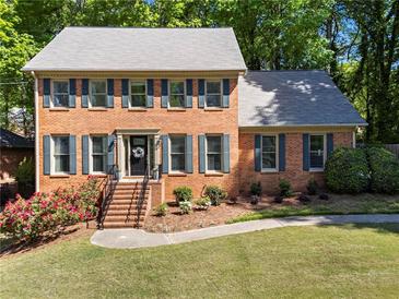 Charming brick two-story home with a well-manicured lawn and blooming flower beds at 2801 Livsey Dr, Tucker, GA 30084