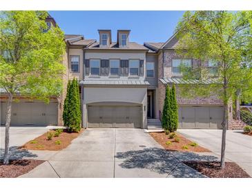 Charming townhome with a two-car garage, manicured landscaping, and classic architectural details at 1005 Milhaven Dr, Roswell, GA 30076