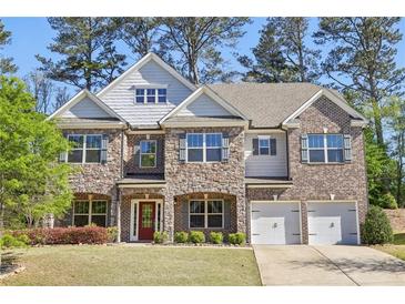 Charming two-story home featuring a stone and brick facade, complemented by a well-manicured lawn and a two-car garage at 4775 Columbia St, Cumming, GA 30040