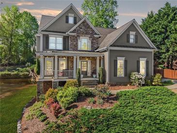 Charming two-story home with a combination of stone and siding and professionally landscaped front yard at 975 Garden Crossing Ln, Cumming, GA 30040