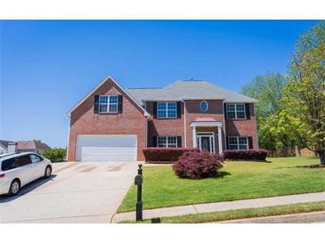 Charming two-story brick home with a well-manicured lawn and a two-car garage at 100 Wyngate Chase, Stockbridge, GA 30281