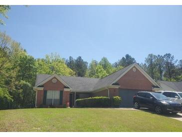 Charming single-story brick home with a well-maintained lawn and attached garage in a quiet suburban neighborhood at 70 Pebble Brooke Pass, Covington, GA 30016