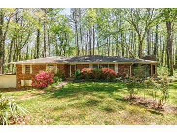 Charming brick home surrounded by lush greenery and flowering shrubs at 2680 Irene Dr, Marietta, GA 30066