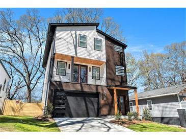 Stunning two-story home with modern design, a small balcony, and an attached garage at 676 S Grand Nw Ave, Atlanta, GA 30318