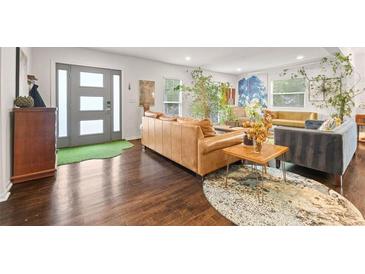 Bright living room with hardwood floors, modern decor, and a stylish front door at 3143 Church St, East Point, GA 30344