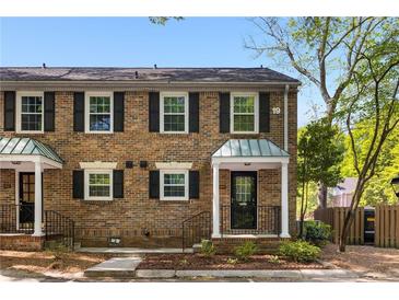 Charming brick townhome featuring classic shutters and a well-maintained front yard with stone and mulch at 6700 Roswell Rd # 19F, Atlanta, GA 30328