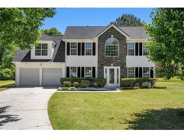 Charming two-story home with a well-manicured lawn, two-car garage, and beautiful landscaping at 1076 Field View Dr, Mcdonough, GA 30253