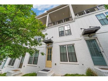 Modern townhome featuring brick, white siding, black accents, and a second story balcony at 1227 Cushenberry Ln, Atlanta, GA 30318
