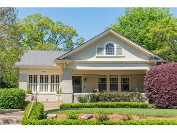 Charming home with a brick facade, lush landscaping, and inviting front porch, perfect for relaxing and enjoying the outdoors at 1012 Bellevue Ne Dr, Atlanta, GA 30306