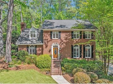 Charming two-story brick home with manicured landscaping and a welcoming front entrance at 2885 Arborwoods Dr, Alpharetta, GA 30022