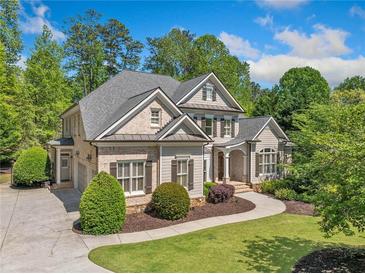 Charming two-story home featuring manicured landscaping, a curved walkway, and a blend of brick and siding accents at 330 Plantation Way, Roswell, GA 30075