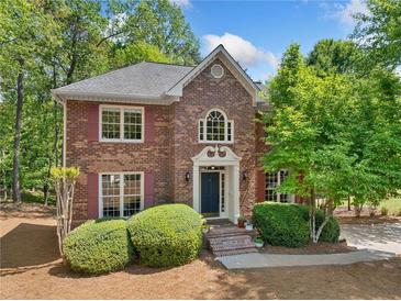 Charming brick home with manicured landscaping and mature trees offering great curb appeal at 3585 Legacy Trce, Alpharetta, GA 30022