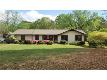 Charming ranch home with well-maintained lawn and colorful azalea bushes along the front at 4909 Woodhurst Way, Stone Mountain, GA 30088