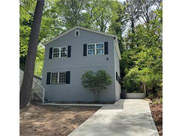 Charming two-story home with gray siding, black shutters, and a newly poured concrete driveway at 948 Reed Ave, Atlanta, GA 30344