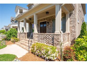 Charming front porch with brick accents, columns, and a welcoming entrance with beautiful landscaping at 168 Brighton Blvd, Woodstock, GA 30188