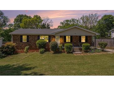 Charming brick home with a well-maintained lawn and inviting curb appeal, black shutters, and a cozy front porch at 1085 Azalea Ne Cir, Marietta, GA 30062