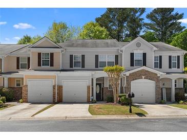 Charming townhome featuring attached garages, beautiful landscaping and inviting front entrances at 1067 Brittania Rd, Stone Mountain, GA 30083