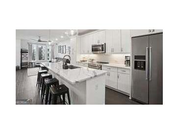 Open kitchen featuring a large island with white countertop and stainless steel appliances at 1050 Stacks Ave # 1507, Atlanta, GA 30315