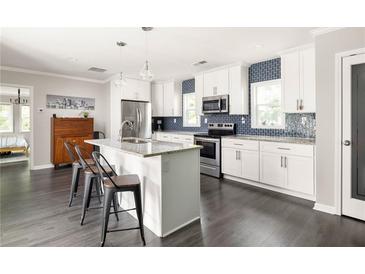 Bright kitchen featuring white cabinetry, stainless steel appliances, granite countertops, and a stylish island with seating at 1711 Terry Mill Se Rd, Atlanta, GA 30316