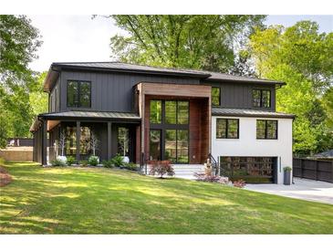 Contemporary two-story home featuring a dark gray exterior with wood accents and a well-manicured lawn at 2469 River Oak Dr, Decatur, GA 30033