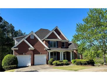 Charming two-story brick home with a well-manicured front yard, two-car garage, and inviting entrance at 71 Tobinleigh Ct, Acworth, GA 30101