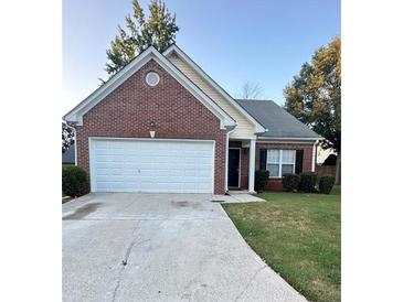 Charming single-story brick home with a two-car garage and well-maintained front yard at 4194 Wesley Ln, Decatur, GA 30035