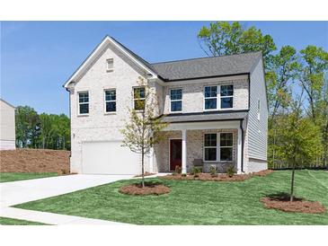 Charming two-story home boasts a white brick facade, attached garage, and neatly manicured lawn at 608 Belshire Dr, Acworth, GA 30102