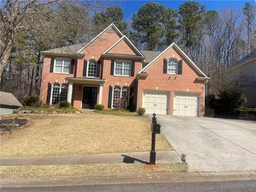 Charming two-story brick home featuring a two-car garage and well-manicured front lawn at 713 Parkside Dr, Woodstock, GA 30188