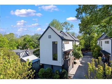 Striking modern home with white siding, dark trim, lush landscaping, and private driveway on a sunny day at 1331 Iverson Ne St # A, Atlanta, GA 30307
