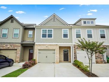 Charming townhome with three units, featuring a well-manicured lawn and individual driveways and garages at 6322 Scudders Dr, Lithonia, GA 30058