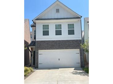 Charming two-story home with white siding, stone accents, and a spacious two-car garage, creating a welcoming facade at 251 Turner Ln, Woodstock, GA 30188