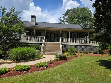 Charming single-Gathering home featuring a large front porch and beautifully landscaped front yard at 1424 Belmont Rd, Villa Rica, GA 30180