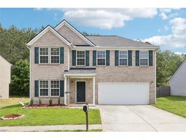 Charming two-story home with a well-manicured lawn and a two car garage at 6904 Estepona St, Atlanta, GA 30349