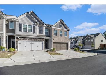 Beautiful townhome with a two-car garage and charming brick and siding exterior at 7676 Viking Rd, Fairburn, GA 30213
