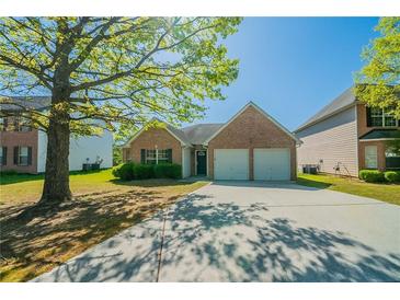 Charming brick home with a two-car garage and a well-maintained front yard and driveway at 1401 Kala Dr, Lithonia, GA 30058