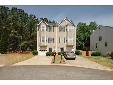 Inviting townhome features a two-car driveway and a well-manicured front yard with mature trees and shrubs at 4486 Thorngate Ln, Acworth, GA 30101