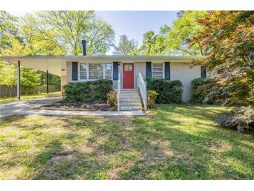 Charming ranch-style home with a red front door, carport, and well-maintained landscaping at 7268 Westwood Ln, Douglasville, GA 30134