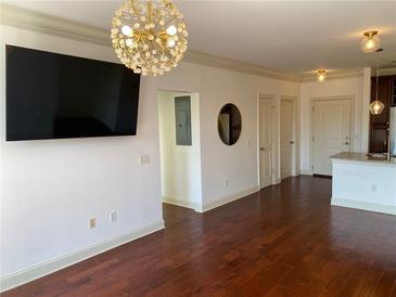 Bright living room with hardwood floors, tv, and modern lighting fixture at 901 Abernathy Ne Rd # 5050, Atlanta, GA 30328