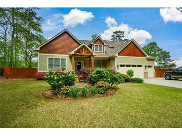 Charming home featuring a colorful front yard with mature landscaping and a two-car garage at 773 Pebblebrook Rd, Mableton, GA 30126