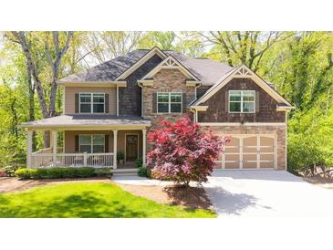 Beautiful two-story home with stone accents, a front porch, and a well-manicured lawn at 925 Upper Hembree Rd, Roswell, GA 30076