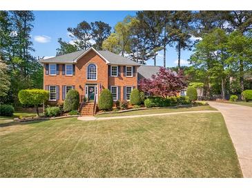 Charming two-story brick home featuring manicured lawn and beautiful landscaping at 744 Edgewater Nw Ln, Kennesaw, GA 30144
