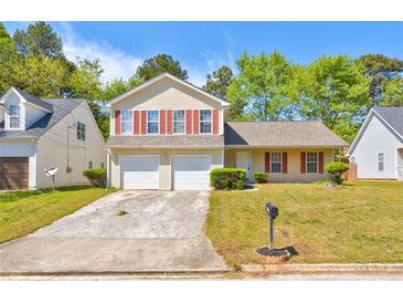 Inviting two-story home with attached two-car garage and well-maintained front lawn at 6396 Phillips Ct, Lithonia, GA 30058