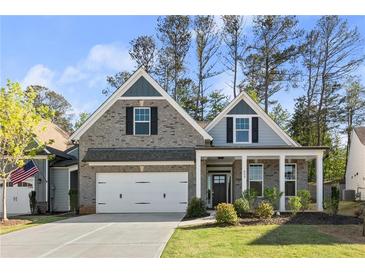 Charming brick home featuring a two-car garage and a welcoming front porch at 809 Kirby Dr, Woodstock, GA 30188