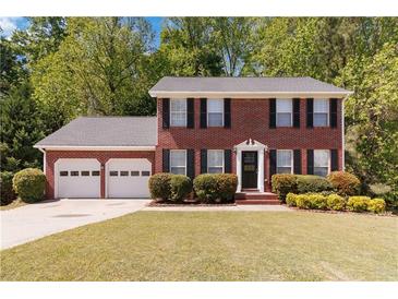 Traditional two-story brick home with a manicured front lawn and attached two car garage at 850 Madison Chase Way, Lawrenceville, GA 30045