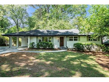 Charming brick home with a well-manicured lawn, covered car port, and inviting curb appeal at 3200 Rehoboth Dr, Decatur, GA 30033